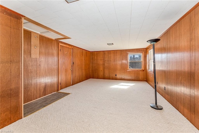 carpeted empty room with wood walls