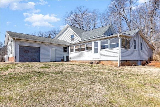 view of front facade featuring a garage, a sunroom, central AC, and a front lawn