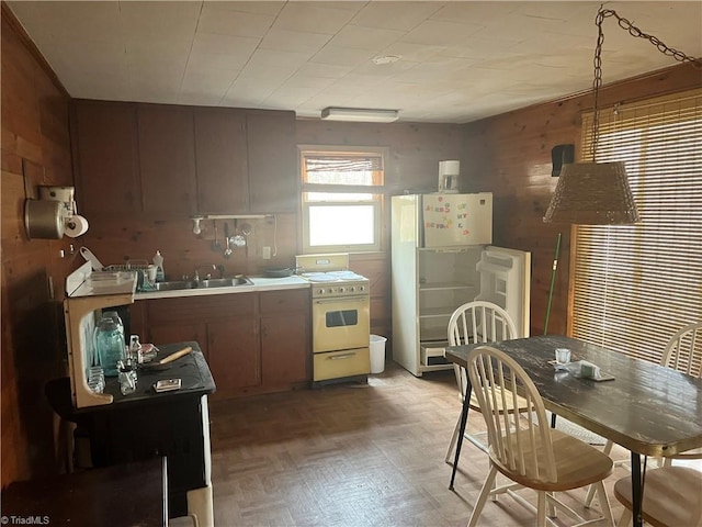 8253 N NC Highway 16, Millers Creek, NC 28651 - kitchen with range, freestanding refrigerator, wooden walls, and light countertops