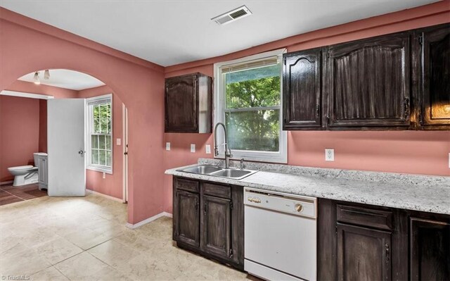 1224 Downing St, High Point, NC 27260 - kitchen with dishwasher, a sink, arched walkways, baseboards, and light tile patterned flooring