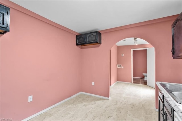 1224 Downing St, High Point, NC 27260 - unfurnished room with arched walkways, a sink, and baseboards