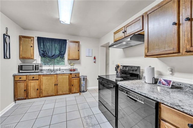 615 Sherman St, Greensboro, NC 27410 - kitchen with black appliances, under cabinet range hood, a sink, brown cabinets, and baseboards
