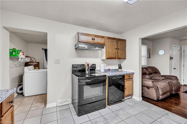 615 Sherman St, Greensboro, NC 27410 - kitchen featuring washer / clothes dryer, black appliances, under cabinet range hood, light tile patterned flooring, and baseboards