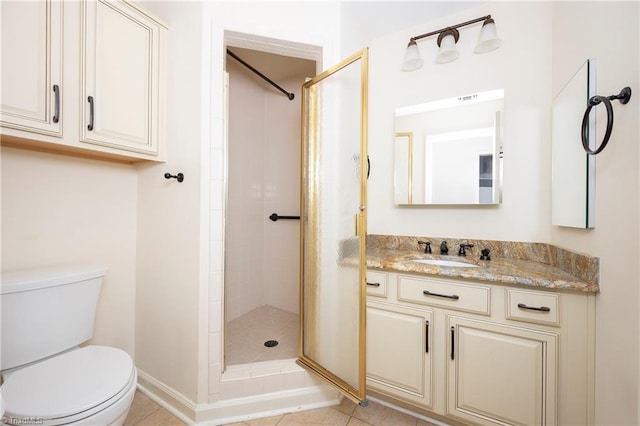 bathroom with tile patterned flooring, a tile shower, vanity, and toilet