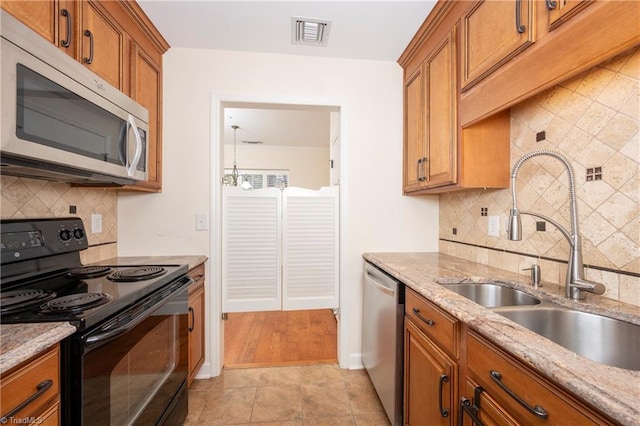 kitchen featuring light stone countertops, stainless steel appliances, light tile patterned floors, and decorative backsplash