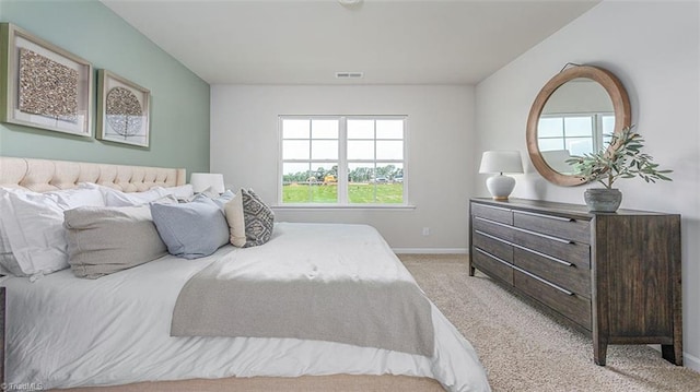 bedroom with light carpet, visible vents, and baseboards