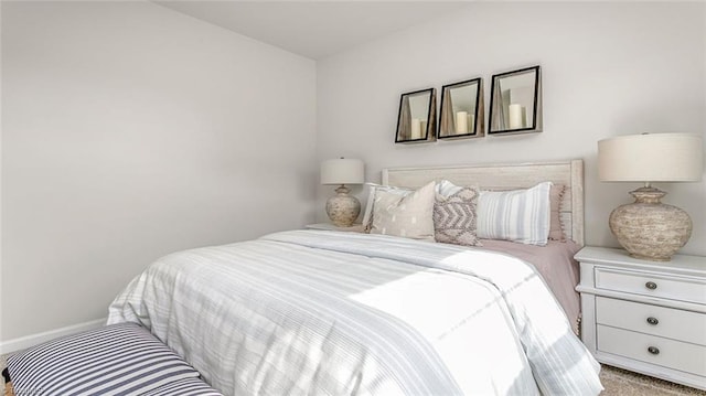 bedroom with light colored carpet and baseboards