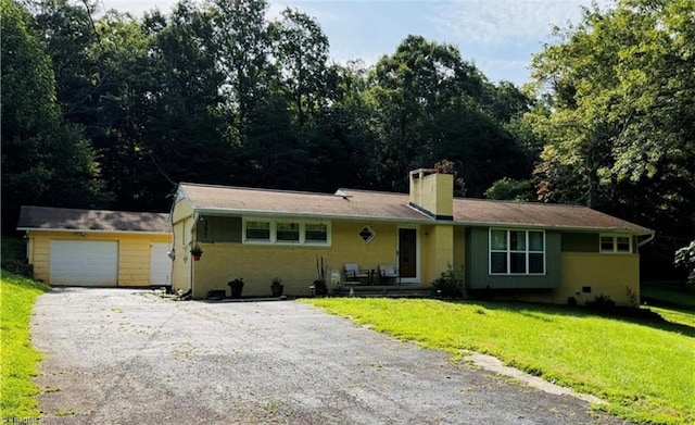 357 Town N Country Dr, Wilkesboro, NC 28697 - ranch-style house featuring a front yard, a chimney, gravel driveway, a garage, and an outbuilding
