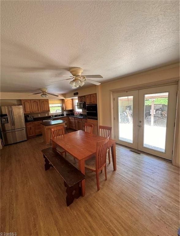 357 Town N Country Dr, Wilkesboro, NC 28697 - dining room with light wood-style floors, a textured ceiling, french doors, and a ceiling fan