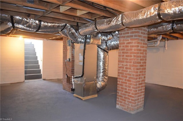 unfinished below grade area with stairway and heating unit