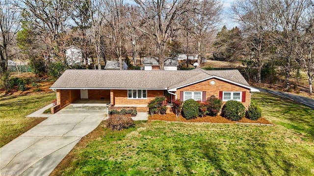 ranch-style home featuring brick siding, an attached carport, a shingled roof, a front lawn, and concrete driveway