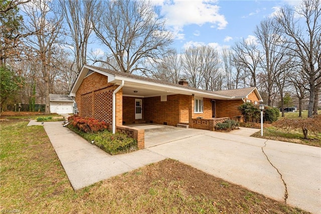 ranch-style house featuring a front yard, driveway, a chimney, a carport, and brick siding