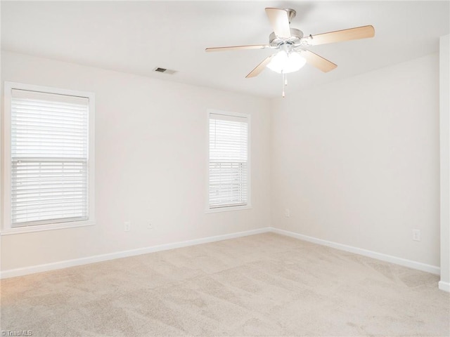 spare room featuring light carpet and ceiling fan