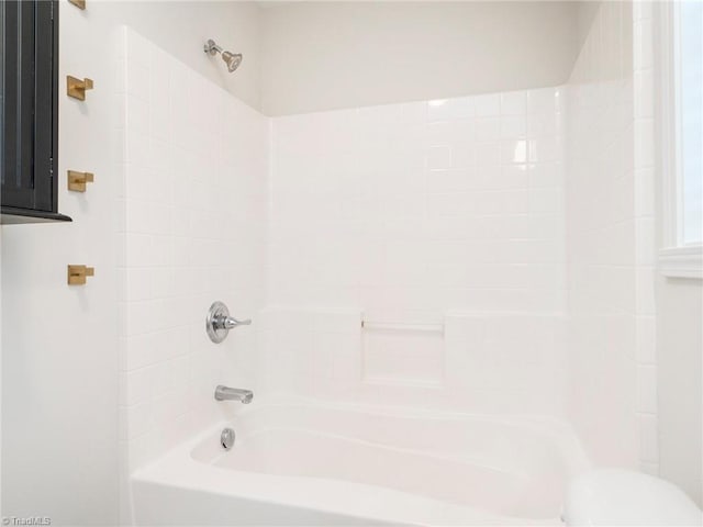 bathroom featuring tub / shower combination and toilet