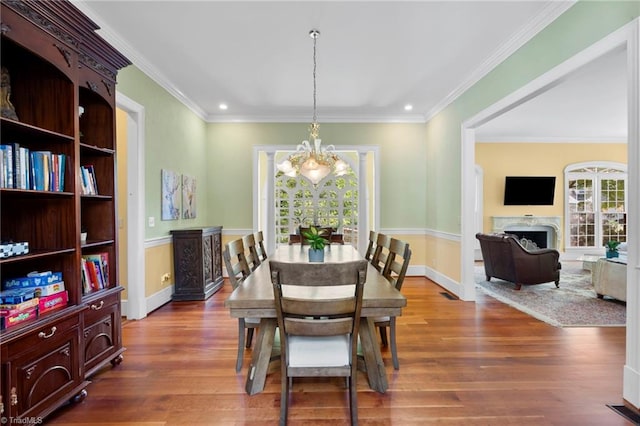 dining space featuring baseboards, a chandelier, recessed lighting, and wood finished floors
