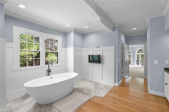 full bathroom with a freestanding bath, ornamental molding, a decorative wall, and recessed lighting