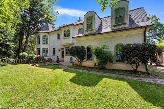 view of front of house with stucco siding and a front lawn