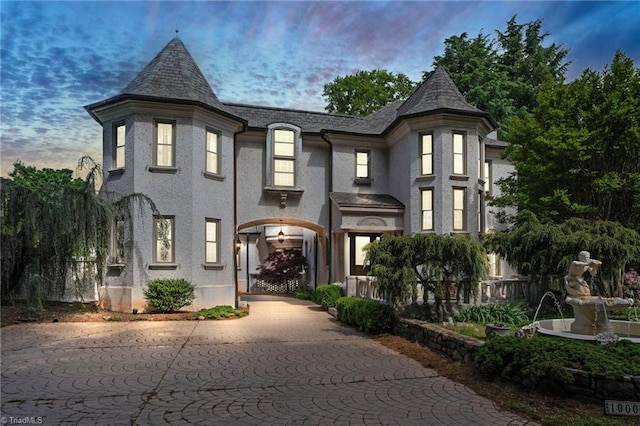 view of front of property featuring fence and a high end roof