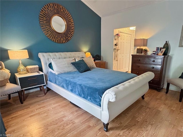 bedroom with ornamental molding, baseboards, wood finished floors, and lofted ceiling