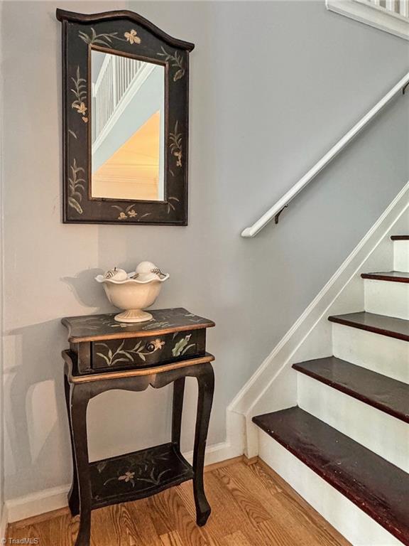 stairway featuring wood finished floors and baseboards