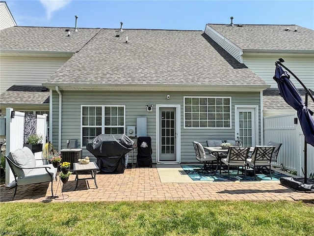 rear view of property featuring central AC unit, a shingled roof, fence, and a patio area