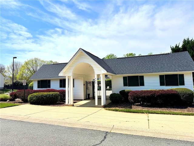 ranch-style house with concrete driveway and a shingled roof