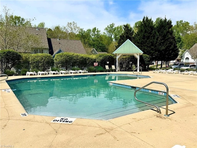pool with a patio and fence