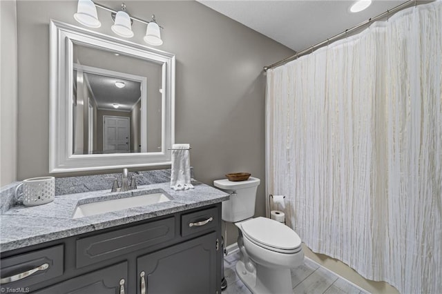 bathroom with toilet, vanity, and walk in shower