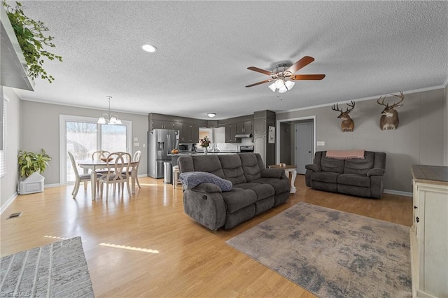 living room with ceiling fan, light hardwood / wood-style flooring, crown molding, and a textured ceiling