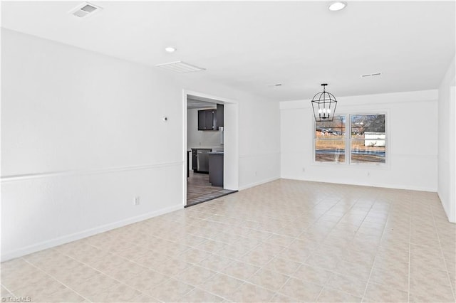 tiled empty room with a chandelier