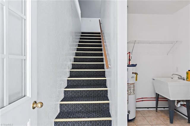 stairs with water heater and tile patterned floors