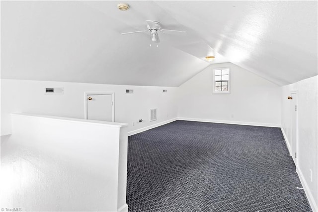 additional living space featuring vaulted ceiling, ceiling fan, and dark carpet