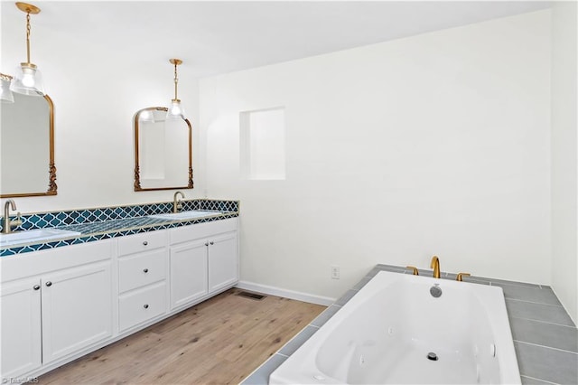 bathroom featuring vanity, wood-type flooring, and a tub