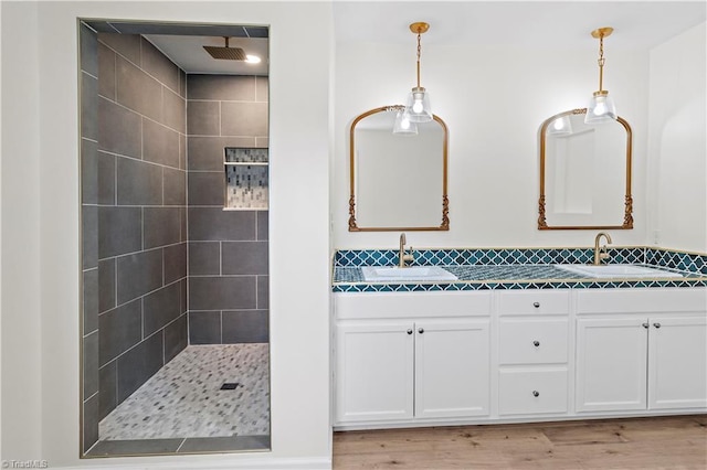 bathroom featuring vanity, hardwood / wood-style floors, and a tile shower