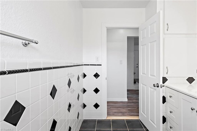 bathroom with tile walls, vanity, and tile patterned floors