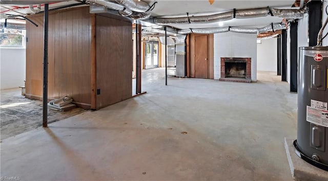 basement with heating unit, a brick fireplace, and water heater