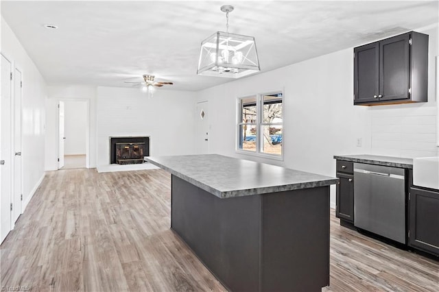 kitchen with ceiling fan, hanging light fixtures, a center island, stainless steel dishwasher, and light wood-type flooring