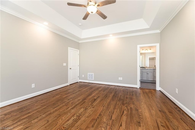 empty room with crown molding, dark wood-type flooring, a raised ceiling, and ceiling fan