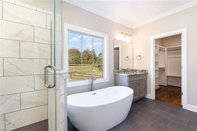 bathroom with independent shower and bath, vanity, ornamental molding, and a wealth of natural light