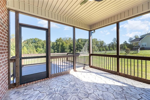 unfurnished sunroom with ceiling fan