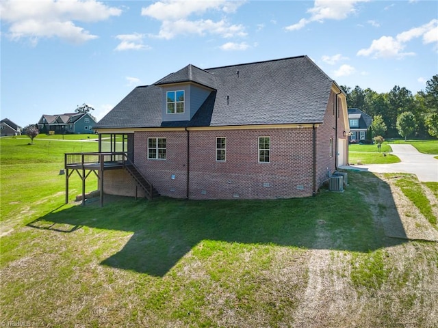 rear view of property featuring central AC unit, a deck, and a lawn