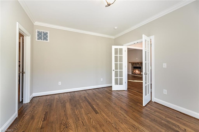 empty room featuring crown molding, dark hardwood / wood-style flooring, and french doors