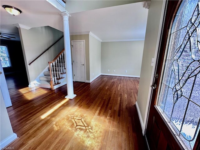 entrance foyer with wood finished floors, crown molding, baseboards, stairs, and ornate columns