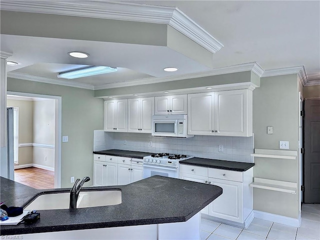 kitchen featuring a sink, white appliances, white cabinets, and crown molding