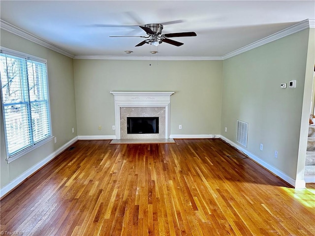 unfurnished living room featuring hardwood / wood-style floors, visible vents, ornamental molding, and ceiling fan