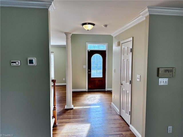 foyer with decorative columns, wood finished floors, baseboards, and ornamental molding