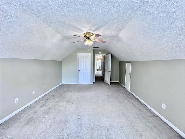 bonus room with baseboards, a textured ceiling, lofted ceiling, and a ceiling fan