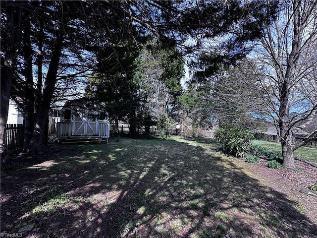 view of yard featuring an outbuilding, a storage unit, and a fenced backyard