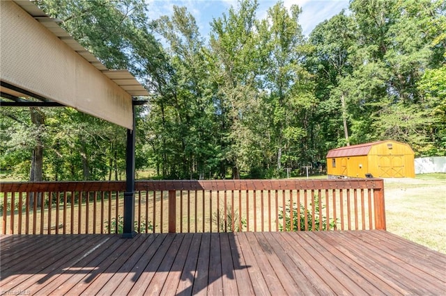 wooden deck featuring a storage shed and a lawn