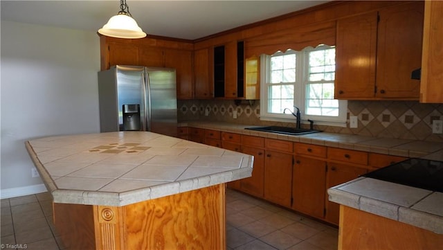 kitchen featuring decorative backsplash, stainless steel refrigerator with ice dispenser, a center island, and sink